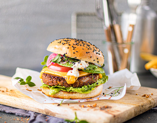 Lecker belegter Insektenburger auf einem Holzbrett